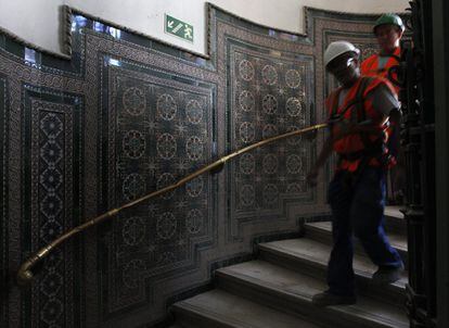 Unos obreros bajan unas escaleras durante las obras de rehabilitación del palacio de Cibeles en 2010.