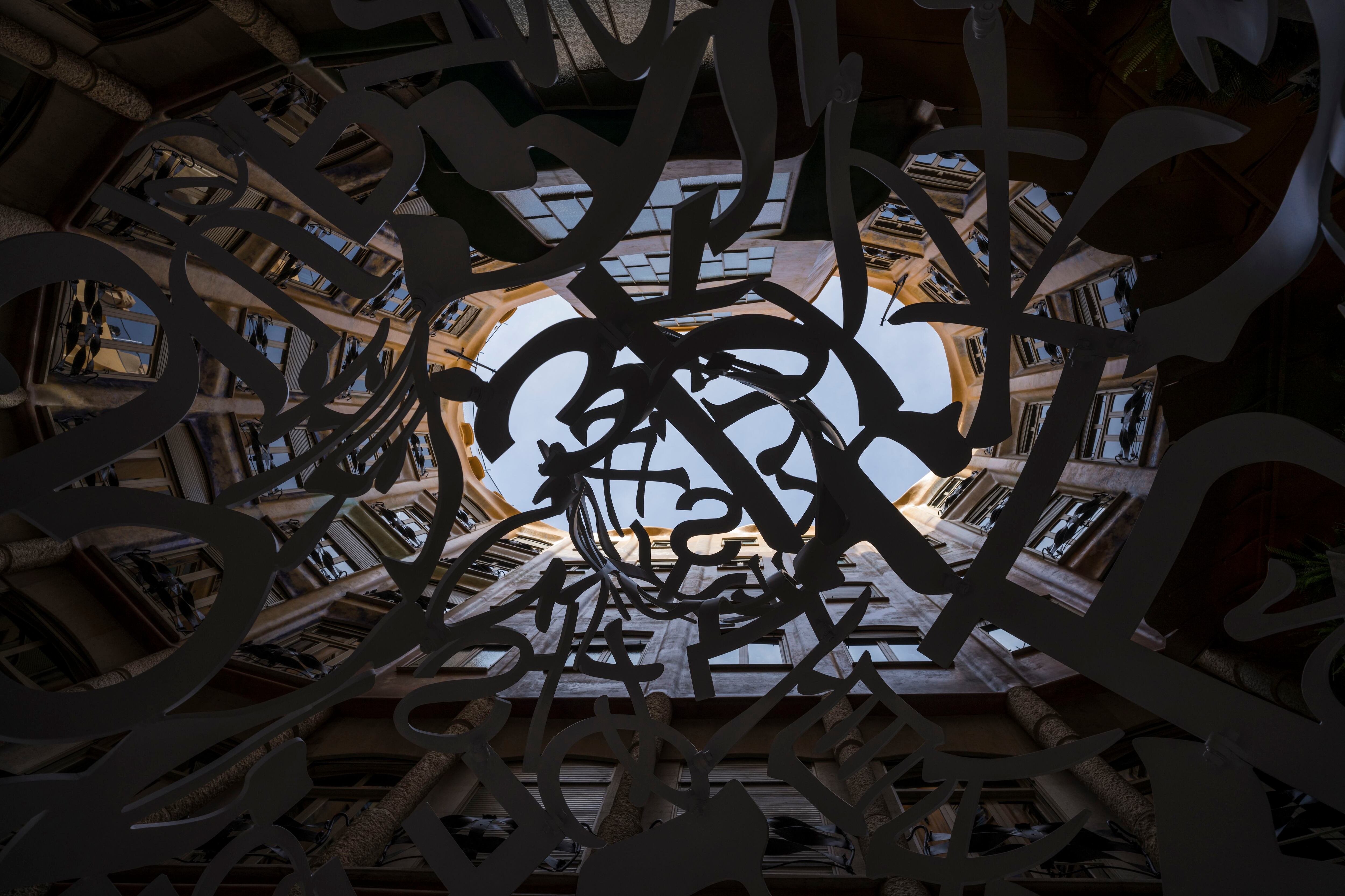 Fotografía tomada desde el interior de una de las monumentales obras de Jaume Plensa en la exposición 'Poesía del silencio' en La Pedrera (Barcelona)