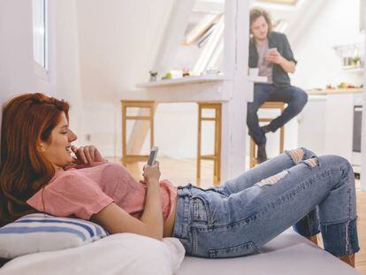 Una pareja utiliza sus teléfonos móviles.