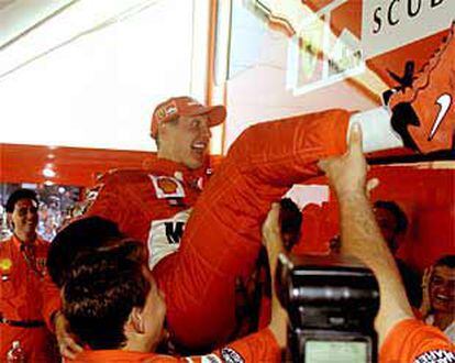 Michael Schumacher es manteado por los miembros del equipo Ferrari.