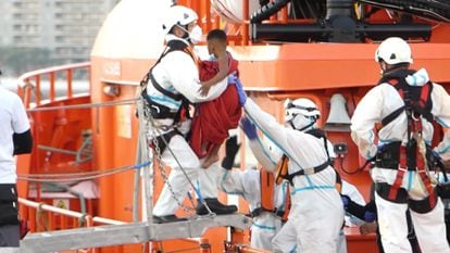 Un miembro de la Cruz Roja ayuda a bajar del barco a un niño migrante en el puerto de Arguineguín (Gran Canaria) el pasado 17 de marzo.