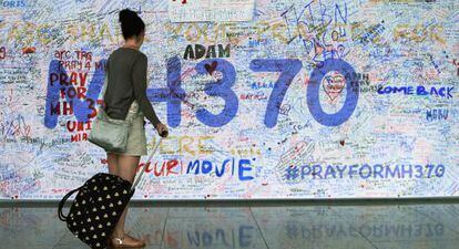 Una joven observa los mensajes de apoyo a las familias escritos en una pared del aeropuerto internacional de Kuala Lumpur.