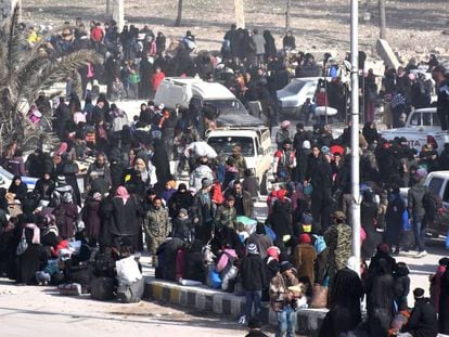 Centenars de sirians esperen en un control del Govern, després d'abandonar la zona est rebel de la ciutat d'Alep.
