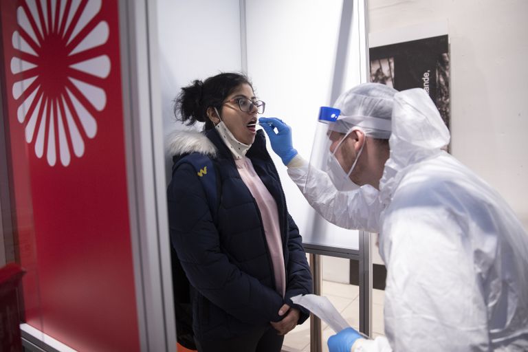 A health worker tests a female passenger for coronavirus this Thursday at the Berlin-Brandenburg airport.