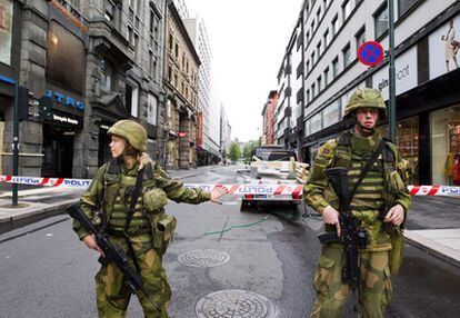 Dos soldados vigilan la zona acordonada tras la explosión de ayer en Oslo.
