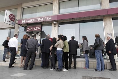 La gente hace cola ante un cajero del Laiki Bank, en Nicosia.