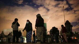Personas llenan contenedores con agua de un tanque de almacenamiento durante el apagón de Ciudad Juárez, el 16 de febrero de 2021.