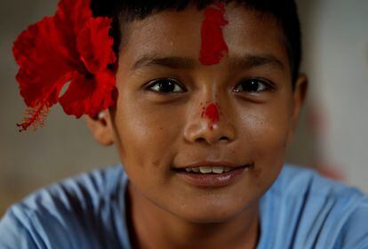 Resham Sunar poses for a photo with a hibiscus flower placed over one ear, in celebration of her 11th birthday. "I feel good about going to school with mom"he assures.