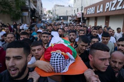 Mourners carry the body of Ayham Shafe'e, 14, during his funeral in the West Bank city of Ramallah