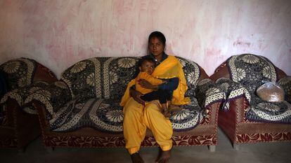 Sonu Bohra  sostiene en brazos a su hijo de dos años en su casa del pueblo de Sal, en el distrito de Champawat, en Uttarakhand (India).