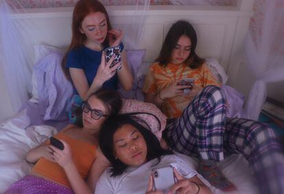 Un grupo de adolescentes utiliza sus teléfonos móviles.