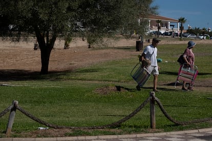 Una pareja atraviesa un parque con césped en Matalascañas, el pasado jueves.