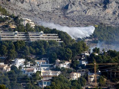 Medios aéreos intentan sofocar este sábado el incendio que desde esta madrugada ha desalojado una treintena de vecinos y cortado la AP-7 y la Nacional 332 en ambos sentidos.