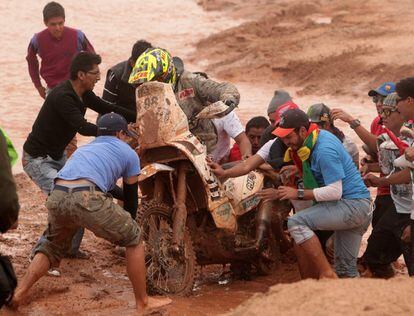 Un grupo de bolivianos ayuda al piloto francés Stephan Hamard a salir del lodo durante la séptima etapa del Dakar en Uyuni, Bolivia.