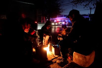 Una familia calienta tortillas en una pequeña hoguera a las afueras de su casa en Monterrey, afectada por el apagón masivo.
