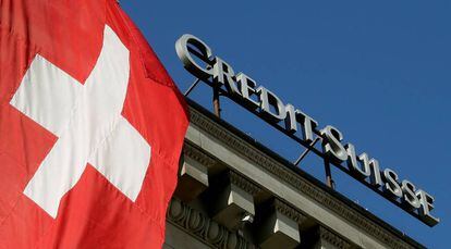 La bandera nacional de Suiza ondea junto al logotipo del banco suizo Credit Suisse en la ciudad de Lucerna.