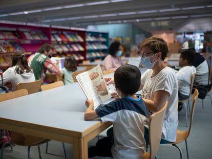 Una madre y su hijo leen en la biblioteca Maria Moliner de Villaverde, Madrid.