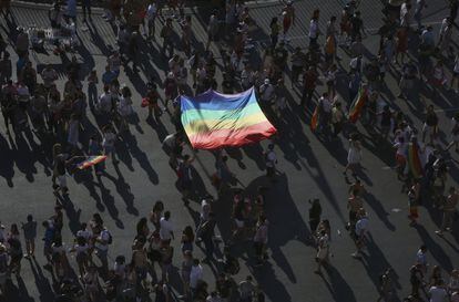 Varias personas ondean una bandera arco iris durante la manifestación del Orgullo en Madrid