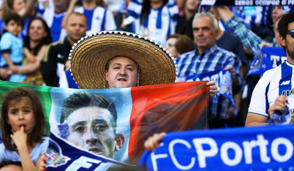 Un aficionado muestra una bandera mexicana con el rostro de Herrera.