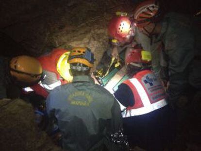 Fotografía facilitada por la Guardia Civil de varios agentes y efectivos del Servicio de Emergencias atendiendo al espeleólogo.