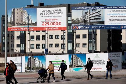 Viandantes pasan por delante de varios anuncios de viviendas, el pasado octubre en Madrid.