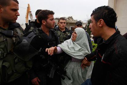 Una mujer palestina se enfrenta a los policías que custodian la casa durante la demolición.