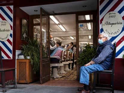 Un hombre espera su turno en el exterior de una peluquería en el centro de Madrid, este lunes.