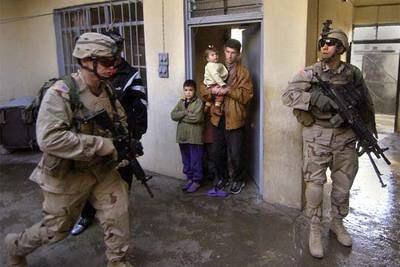 Militares estadounidenses registran viviendas en Mosul.