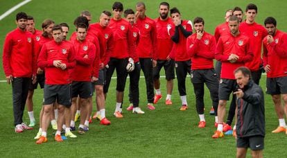 Los jugadores del Atlético escuchan las instrucciones del preparador físico, Óscar Ortega.