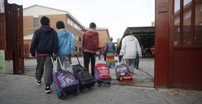 Varios niños entran en el colegio público La Latina en Aluche.