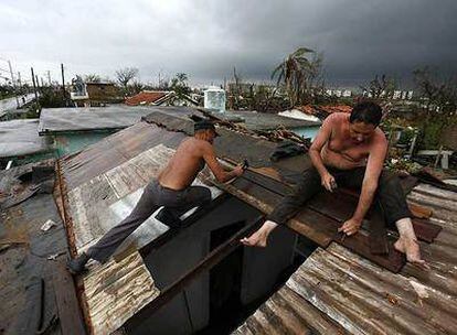 Carlos Casanueva intenta reparar el techo de su casa con unas tablas en la localidad de Los Palacios.