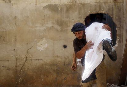 Rebeldes sirios trasladan el cuerpo de uno de sus compañeros durante los combates en Alepo.
