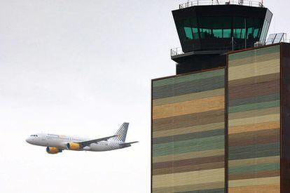 Un avión pasa junto a la torre de control del aeropuerto de Alguaire, en Lleida, el día de su inauguración.