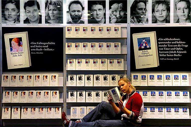 Una joven lee delante de uno de los expositores de la Feria del Libro de Fráncfort.