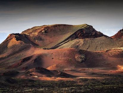 Un autobús turístico en la ruta de las Montañas del Fuego, en el parque nacional de Timanfaya, en Lanzarote.