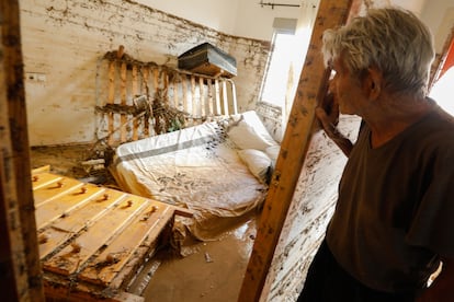 Un hombre observa el dormitorio de su casa tras la inundación, en la pedanía de Javalí Viejo.