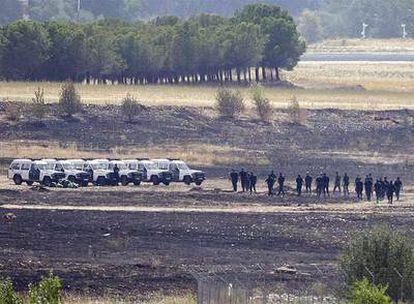 Agentes de la Guardia Civil inspeccionan el lugar del accidente del avión de Spanair junto al aeropuerto de Barajas.