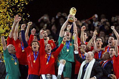 Casillas levanta la copa de campeones del mundo rodeado por sus compañeros.