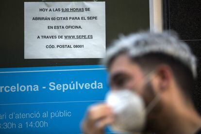 Persona amb mascareta fent cua a l'Oficina de Treball de la Generalitat, a Barcelona.