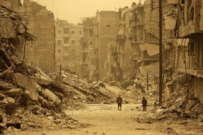 Dos ciudadanos caminan por la ciudad destruida de Alepo, en Siria, el 10 de marzo de 2017.