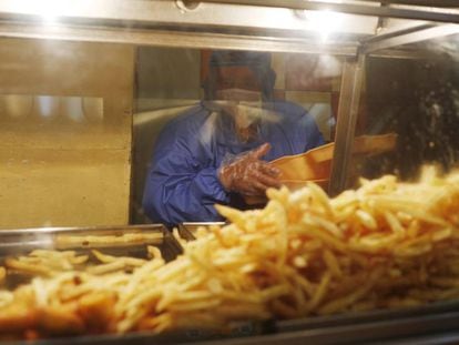 Un empleado de un restaurante de comida rápida de La Paz (Bolivia) coge patatas fritas.