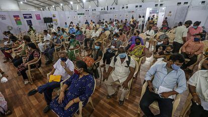 Un grupo de ciudadanos de Bombay espera los efectos de la vacuna contra el coronavirus este viernes en un centro de vacunación.