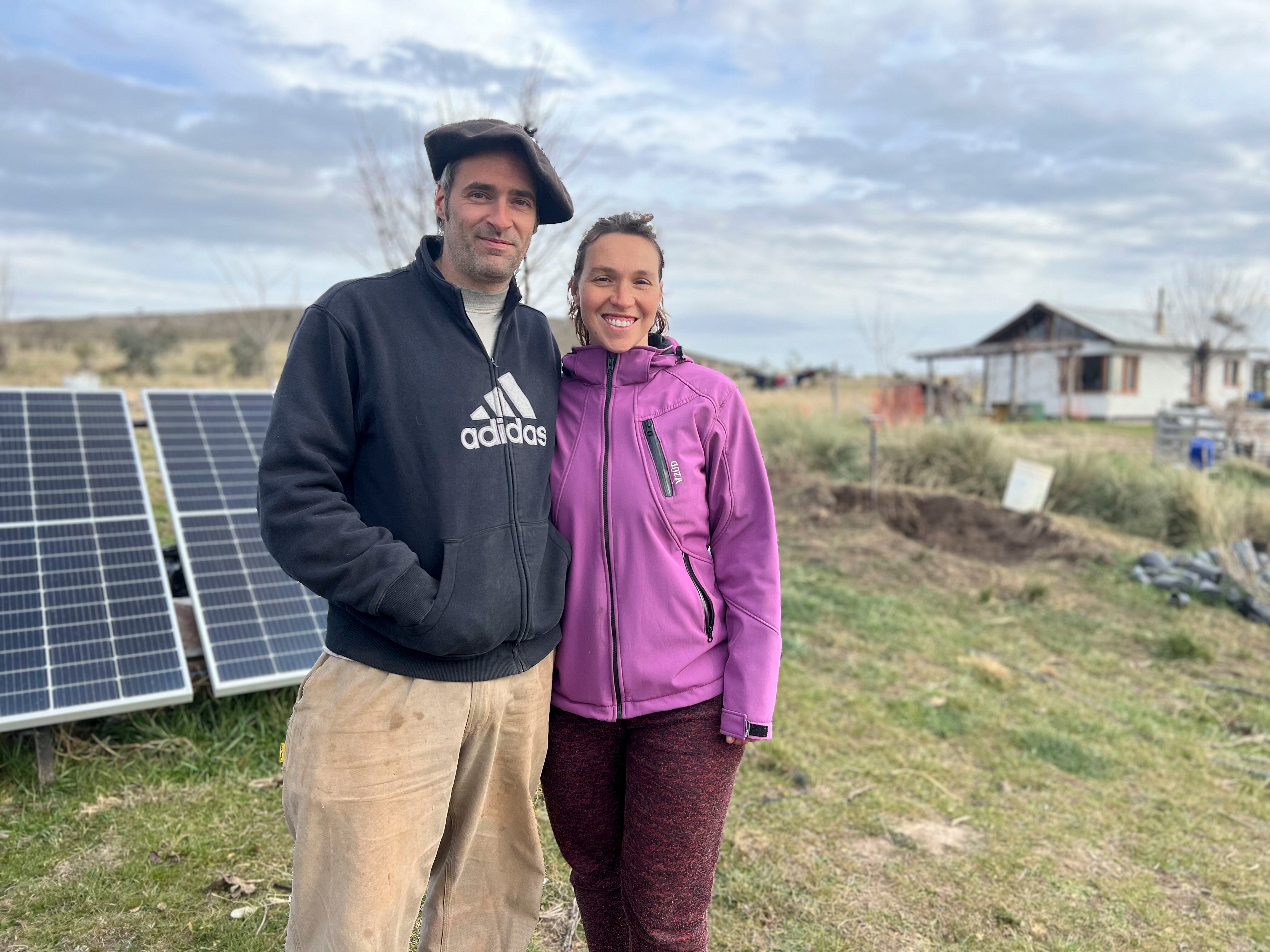 Ignacio Citti y su pareja frente a los paneles solares.