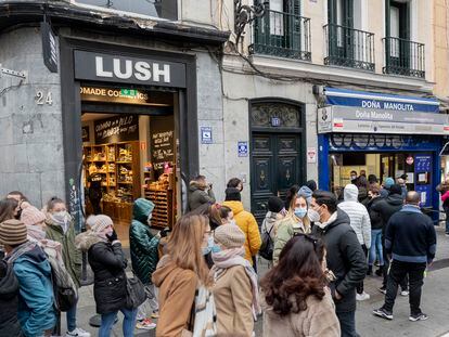 Varias personas hacen cola en la administración de lotería 'Doña Manolita', en Madrid.