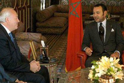 El rey Mohamed VI conversa con el ministro español Miguel Angel Moratinos, durante su encuentro en Tánger.
