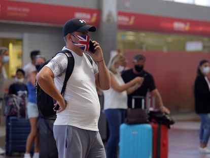 Viajeros con destino al Reino Unido hacen cola para facturar en el aeropuerto de Tenerife Sur, en Granadilla de Abona, Tenerife, este domingo.