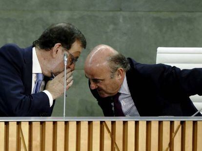El presidente del Gobierno, Mariano Rajoy, habla con Luis de Guindos, ministro de Econom&iacute;a.