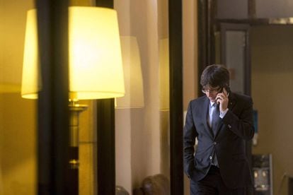 El presidente de la Generalitat, Carles Puigdemont, habla por teléfono en los pasillos del parlamento de Cataluña.