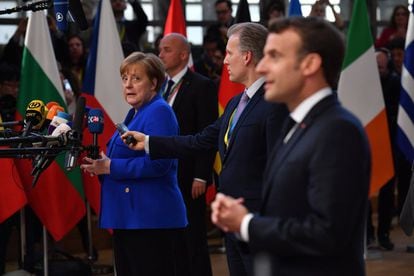 La canciller alemana, Angela Merkel, lanza una mirada al presidente francés, Emmanuel Macron, durante una breve comparecencia de ambos ante los medios de comunicación en el Consejo Europeo de este miércoles.