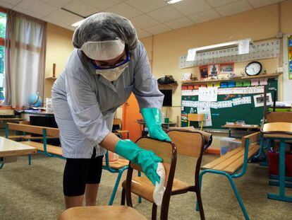 Una trabajadora desinfecta una clase antes del arranque del curso en Francia